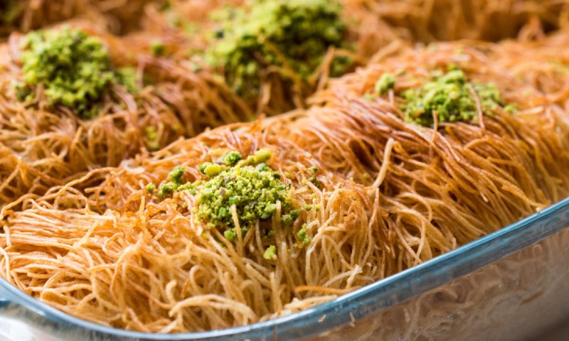 Golden-brown kataifi pastry nests are topped with vibrant green crushed pistachios